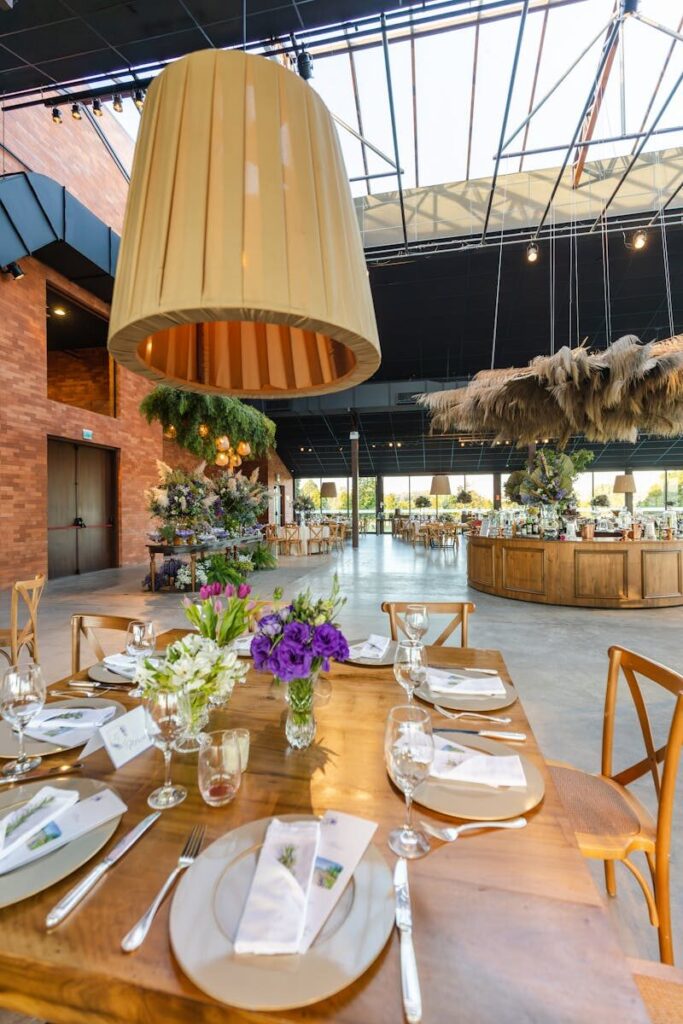 A beautifully set rustic dining table with elegant floral decor, ideal for weddings or events.